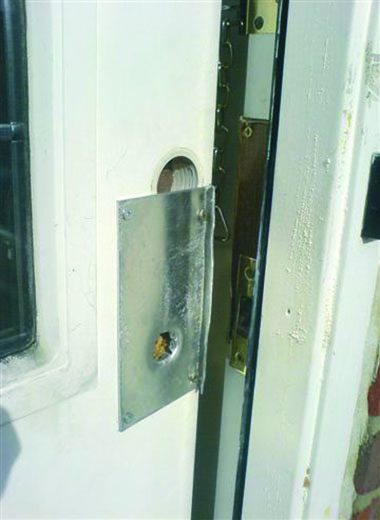 A plate screwed over a drilled-out lock